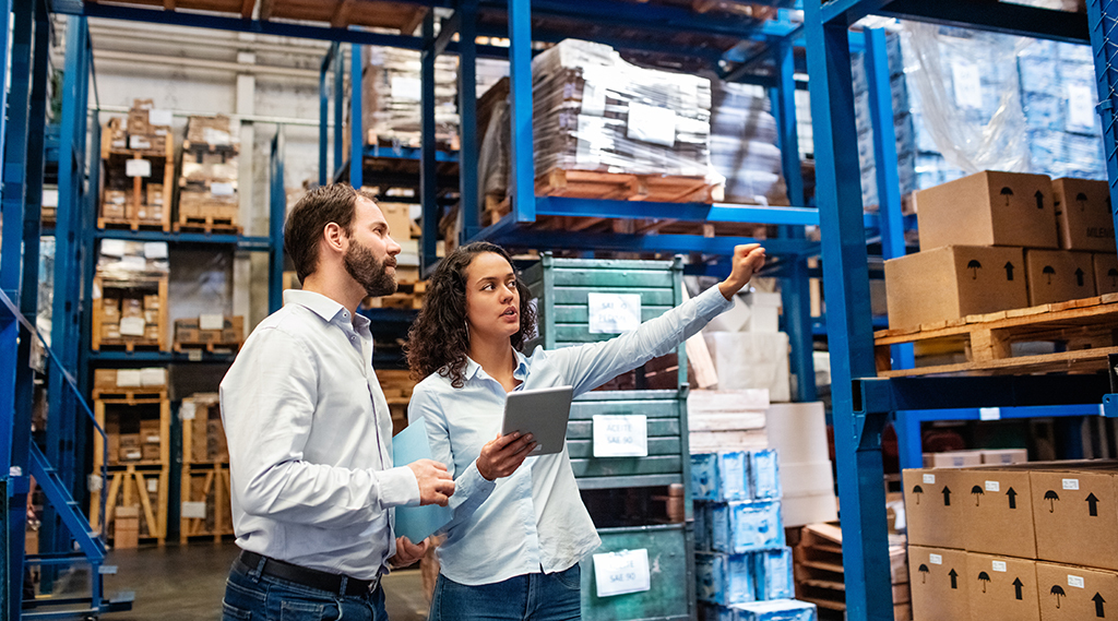 manager and supervisor taking inventory in warehouse