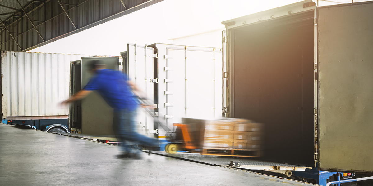 Workers unloading cargo out of container trucks.