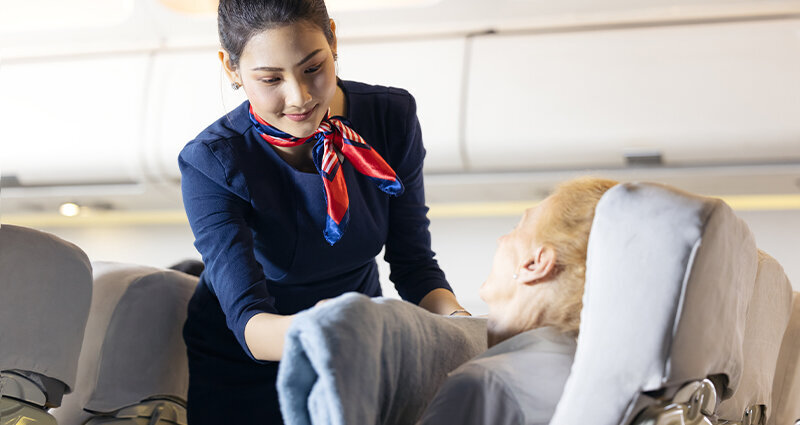 flight attendant helping passenger