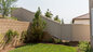 Vinyl privacy fence installed around a landscaped residential backyard